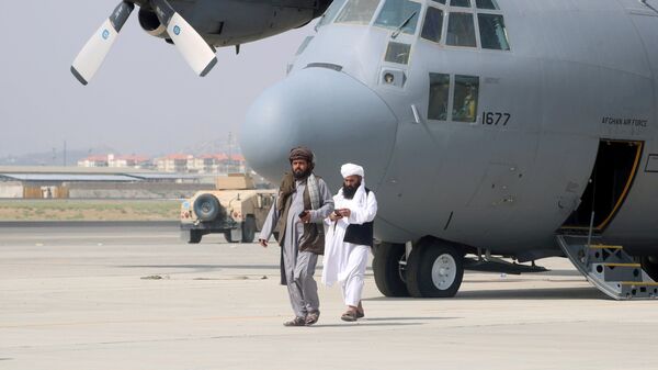 Taliban walk in front of a military airplane a day after the U.S. troops withdrawal from Hamid Karzai International Airport in Kabul, Afghanistan August 31, 2021. - Sputnik International