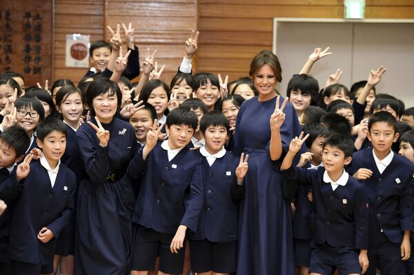 Former US First Lady Melania Trump and former Japanese Prime Minister Shinzo Abe's wife Akie pose for a photo with schoolchildren upon arrival at Kyobashi Tsukiji Elementary School in Tokyo, 6 November 2017. - Sputnik International
