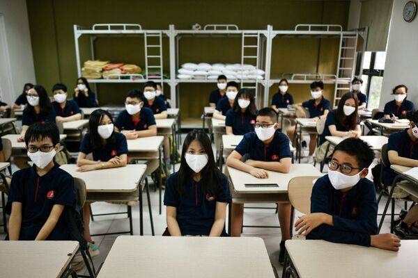 Students wearing face masks sit inside a classroom at the Marie Curie School in Hanoi on 4 May 2020, as schools re-opened after a three-month closure to combat the spread of the COVID-19 pandemic. - Sputnik International