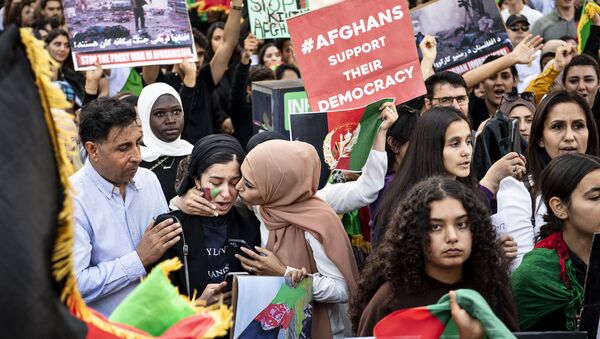 Protesters wave national Afghan flags and hold banners during a rally against Pakistan's involvement in  Afghanistan following the take over of the country by the Taliban in front of the Pakistani Embassy in Copenhagen, Denmark, on August 22, 2021 - Sputnik International