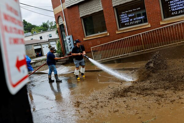 Members of the Oakdale Fire Department clear debris from the street after heavy rains from the storm Ida caused flooding in Oakdale, Pennsylvania, US, 1 September 2021.   - Sputnik International