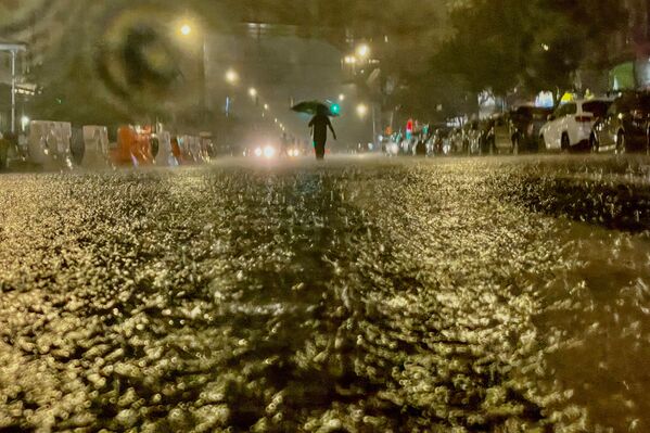 A person makes their way through rainfall amid the aftermath of Hurricane Ida on 1 September 2021, in the Bronx borough of New York City. The formerly Category 4 hurricane passed through New York City, dumping 3.15 inches of rain in the span of an hour at Central Park.    - Sputnik International
