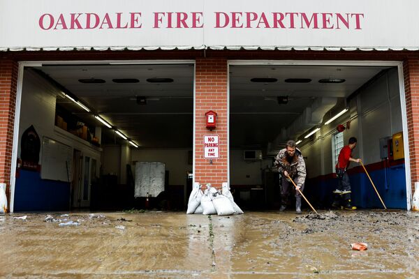 Members of the Oakdale Fire Department clear debris from their station after heavy rains from the storm Ida caused flooding in Oakdale, Pennsylvania, US, 1 September 2021.   - Sputnik International