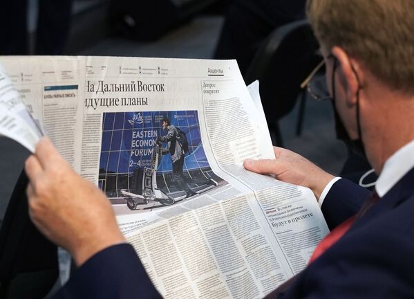 A participant at the Eastern Economic Forum in Vladivostok reads a newspaper before a session. - Sputnik International
