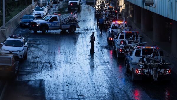 A member of the NYPD supervises tow trucks clearing cars abandoned on the Major Deegan Expressway after the remnants of Tropical Storm Ida brought drenching rain, flash floods and tornadoes to parts of the northern mid-Atlantic, in the Bronx borough of New York City, U.S - Sputnik International