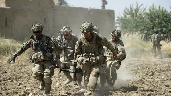A fatally wounded US soldier is carried by comrades during fighting in Afghanistan in August 2011.  - Sputnik International