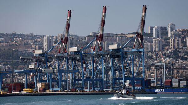 An Israeli military boat makes its way past cranes along the docks of the port of the northern city of Haifa, on June 24, 2021 - Sputnik International