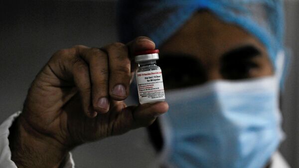 A worker holds a vial of China's Sinovac COVID-19 vaccine produced by VACSERA Co. in Cairo, Egypt July 8, 2021. Picture taken July 8, 2021. - Sputnik International