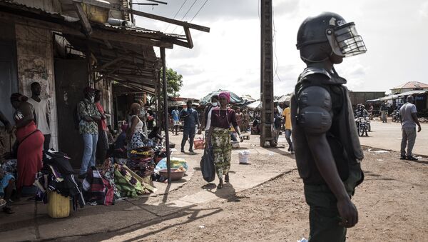 A Police officer stands guard at a round about after mass protests broke out, the morning after preliminary results were released for five communes in Conakry on October 21, 2020.  - Sputnik International