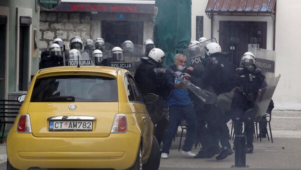 Police officers detain a man during a protest against the enthronement of Bishop Joanikije in Cetinje, Montenegro - Sputnik International