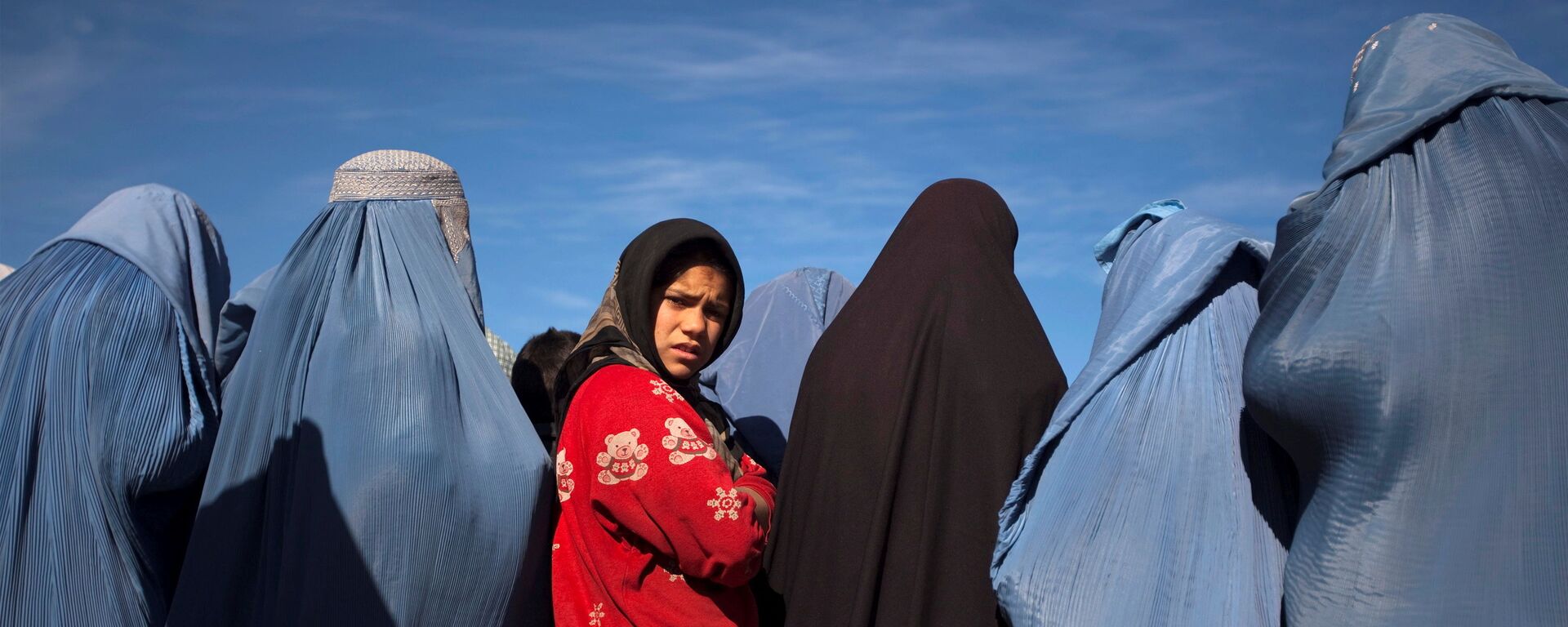 An Afghan girl stands among widows clad in burqas during a cash for work project by humanitarian organisation CARE International in Kabul - Sputnik International, 1920, 07.09.2021