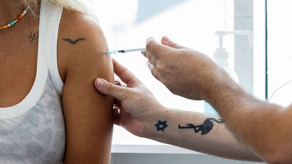 An Israeli woman receives a third shot of coronavirus disease (COVID-19) vaccine in Tel Aviv, Israel August 30, 2021. - Sputnik International