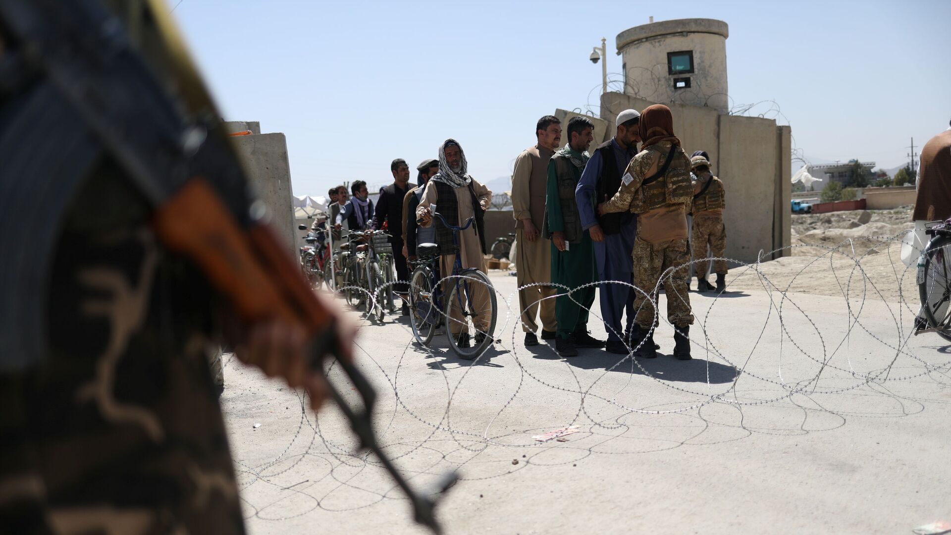 Taliban members pat down workers leaving the military airfield in Kabul, Afghanistan, September 5, 2021 - Sputnik International, 1920, 14.09.2021