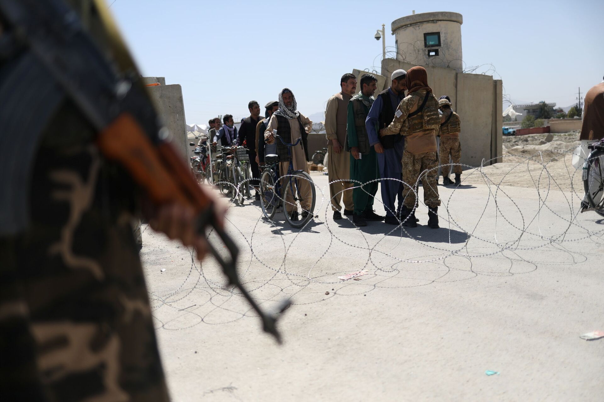 Taliban members pat down workers leaving the military airfield in Kabul, Afghanistan, September 5, 2021 - Sputnik International, 1920, 07.09.2021