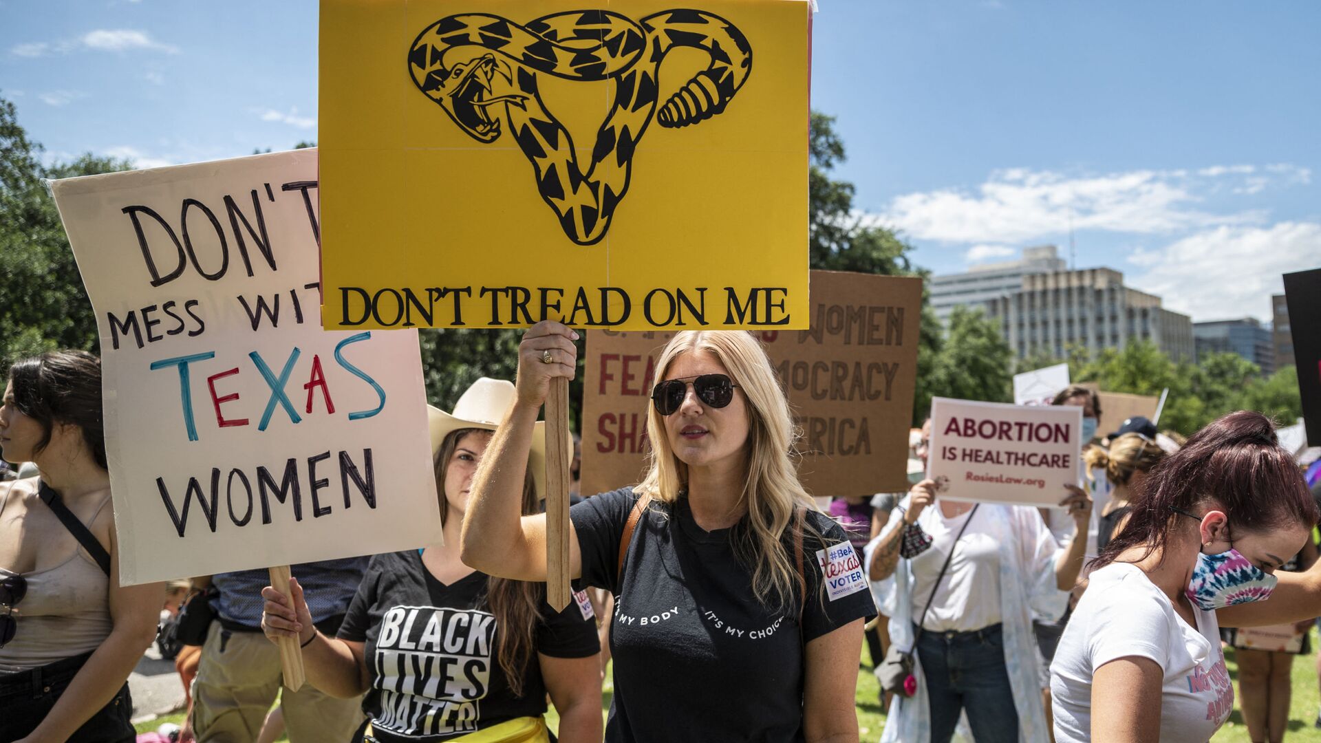 Protesters hold up signs at a protest outside the Texas state capitol on May 29, 2021 in Austin, Texas. - Sputnik International, 1920, 07.10.2021