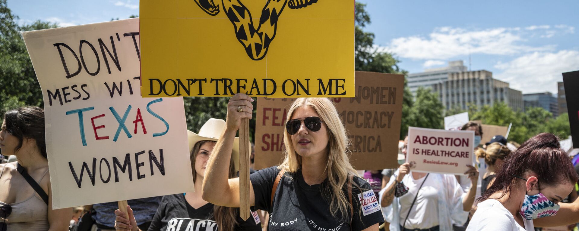 Protesters hold up signs at a protest outside the Texas state capitol on May 29, 2021 in Austin, Texas. - Sputnik International, 1920, 15.07.2022