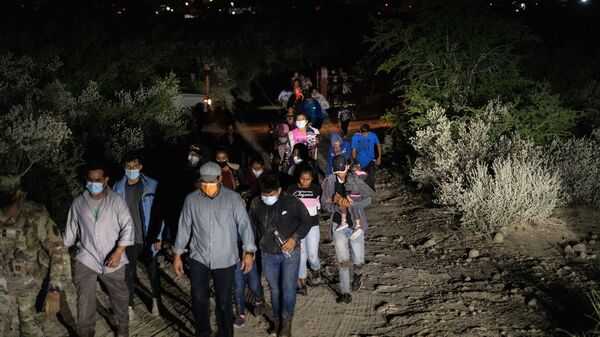Asylum-seeking migrant families are escorted out of a private property by the U.S. National Guard after crossing the Rio Grande river into the United States from Mexico in Roma, Texas, U.S., August 14, 2021 - Sputnik International