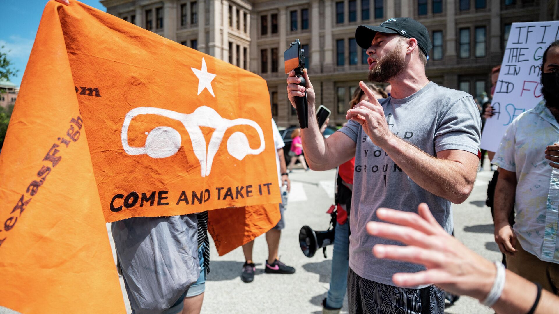 InfoWars host Owen Shroyer records himself disrupting a pro choice protest outside the Texas state capitol on May 29, 2021 in Austin, Texas. Thousands of protesters came out in response to a new bill outlawing abortions after a fetal heartbeat is detected signed on Wednesday by Texas Governor Greg Abbot. - Sputnik International, 1920, 07.09.2021