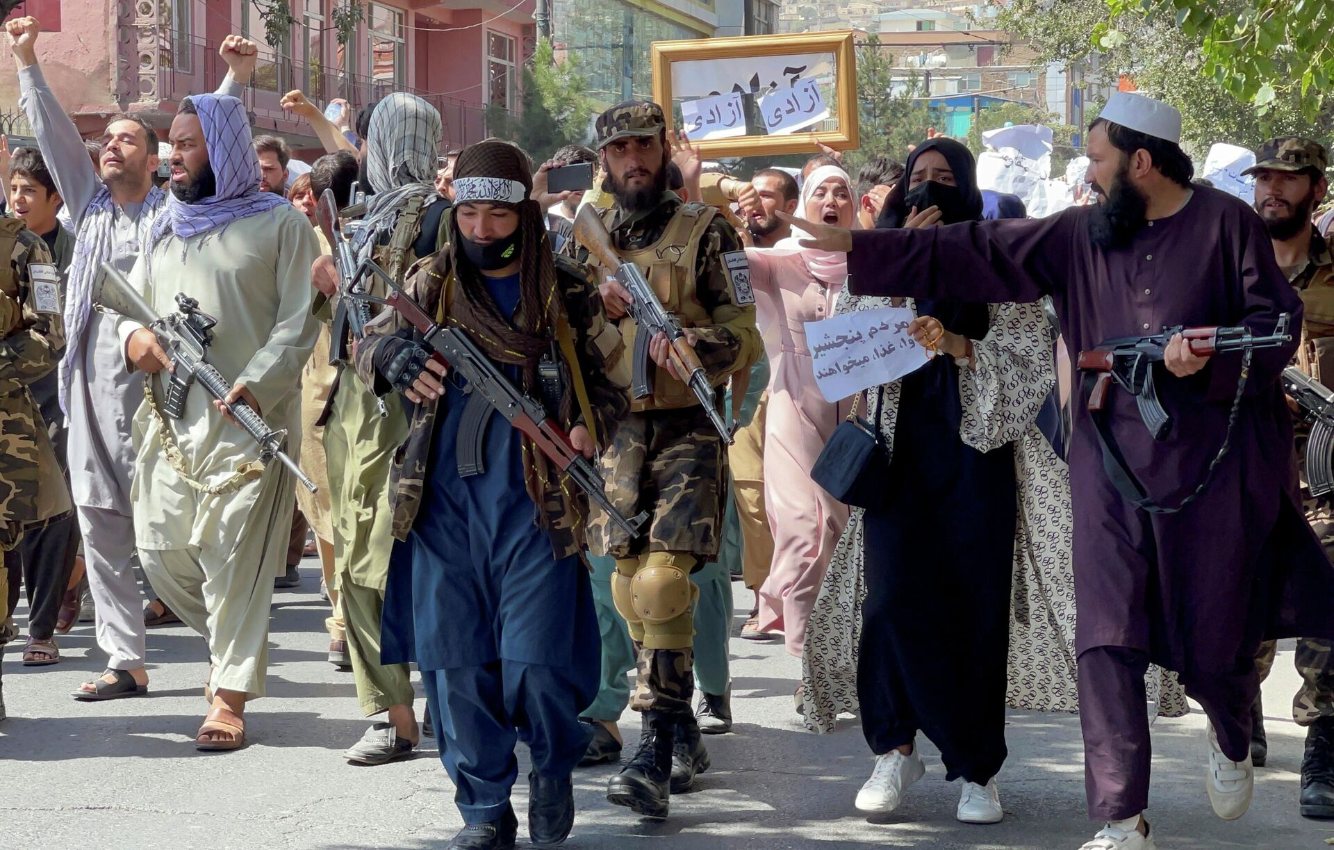 Taliban forces walk in front of Afghan demonstrators as they shout slogans during an anti-Pakistan protest, near the Pakistan embassy in Kabul, Afghanistan, September 7, 2021. REUTERS/Stringer - Sputnik International, 1920, 07.09.2021