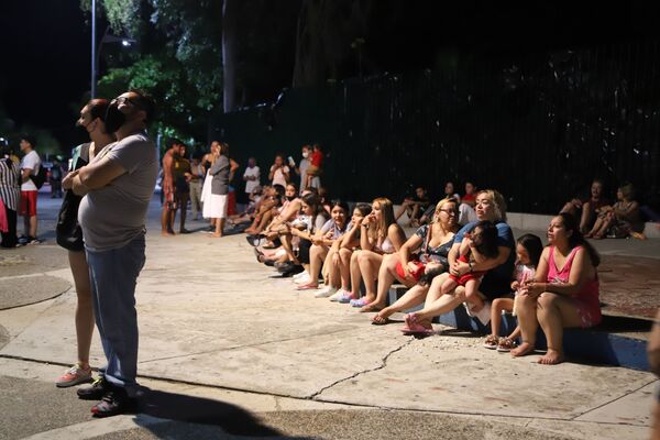 Locals sit on a sidewalk after a strong earthquake in Acapulco, Mexico, on 7 September 2021. - Sputnik International