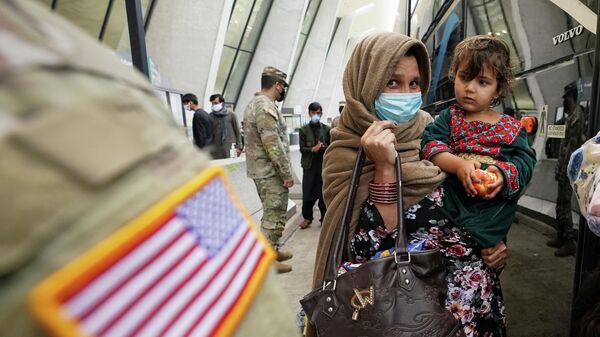 A day after U.S. forces completed its troop withdrawal from Afghanistan, refugees board a bus taking them to a processing center upon their arrival at Dulles International Airport in Dulles, Virginia, U.S.,  September 1, 2021 - Sputnik International