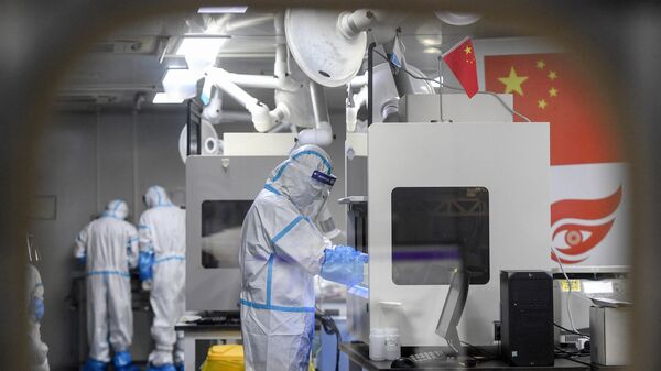 Laboratory technicians wearing personal protective equipment (PPE) work on samples to be tested for the Covid-19 coronavirus at the Fire Eye laboratory, a Covid-19 testing facility, in Wuhan in China's central Hubei province early on August 5, 2021 - Sputnik International