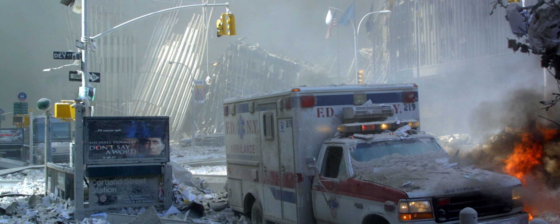 Поврежденный автомобиль скорой помощи и покрытая обломками улица после обрушения первого здания Всемирного торгового центра в Нью-Йорке - Sputnik International, 1920, 11.09.2021