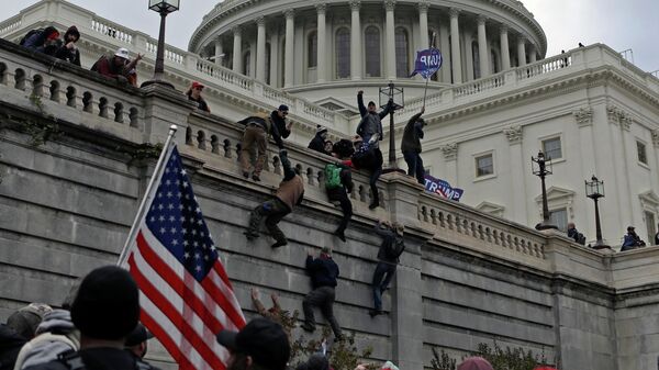 Supporters of U.S. President Donald Trump climb a wall during a protest against the certification of the 2020 presidential election results by the Congress, at the Capitol in Washington, U.S., January 6, 2021. Picture taken January 6, 2021 - Sputnik International
