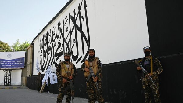 Members of the Taliban Fateh, a special forces unit, stand guard outside the US embassy in Afghanistan displaying a Taliban flag in the outer concrete wall in Kabul on September 8, 2021. - Sputnik International