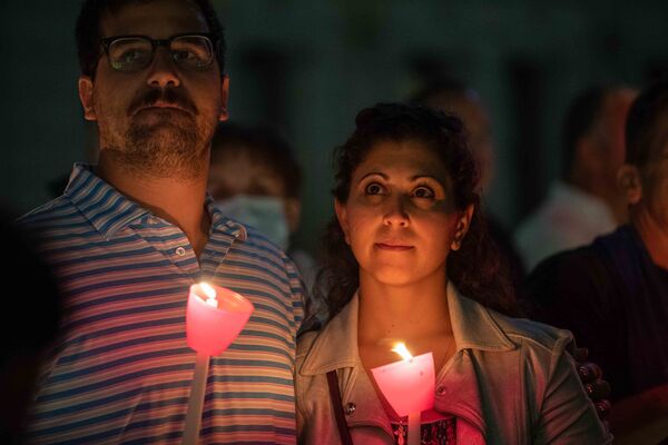 A couple holds candles as they attend a religious 9/11 commemoration ceremony at the Greek Orthodox St. Nicholas National Shrine adjacent to the 9/11 Memorial &amp; Museum in New York City on 10 September 2021. - Sputnik International