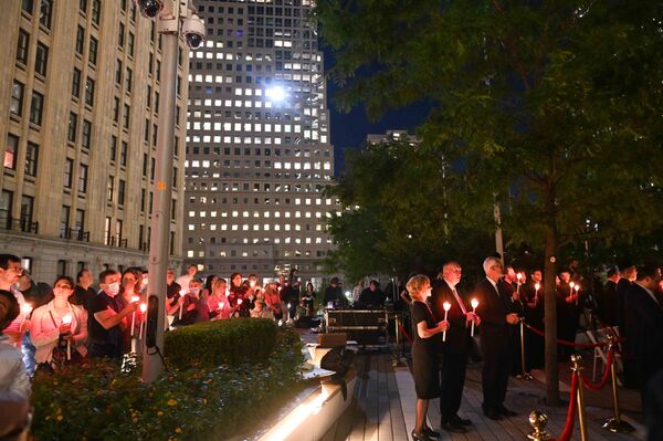 People hold candles as they attend a religious 9/11 commemoration ceremony at the Greek Orthodox St. Nicholas National Shrine adjacent to the 9/11 Memorial &amp; Museum in New York City on 10 September 2021. - Sputnik International