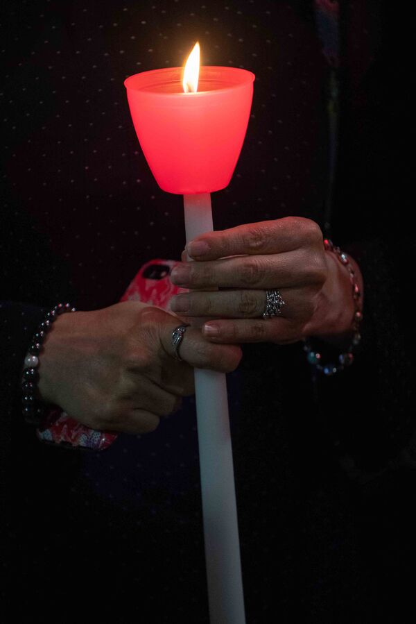 A woman holds a lit candle during a religious 9/11 commemoration ceremony at the Greek Orthodox St. Nicholas National Shrine adjacent to the 9/11 Memorial &amp; Museum in New York City on 10 September 2021. - Sputnik International