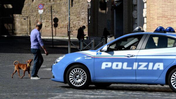 A man walks his dog as a car of the Italian National police patrols on March 19, 2020 in Rome during the lockdown within the new coronavirus pandemic. - Sputnik International