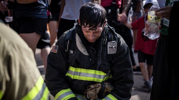 A firefighter in full gear pauses for a moment of silence as he participates with first responders, victim's family members and supporters in the 2021 Colorado 9/11 Memorial Stair Climb at the Red Rocks Park and Amphitheatre on September 11, 2021 in  Morrison, outside Denver, Colorado. - Sputnik International