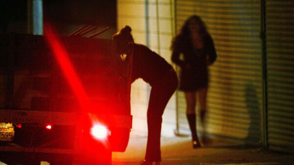 A car slows down for two female police officers posing as prostitutes on Holt Boulevard, known to sex workers throughout southern California as the track, during a major prostitution sting operation November 12, 2004 in Pomona, California - Sputnik International