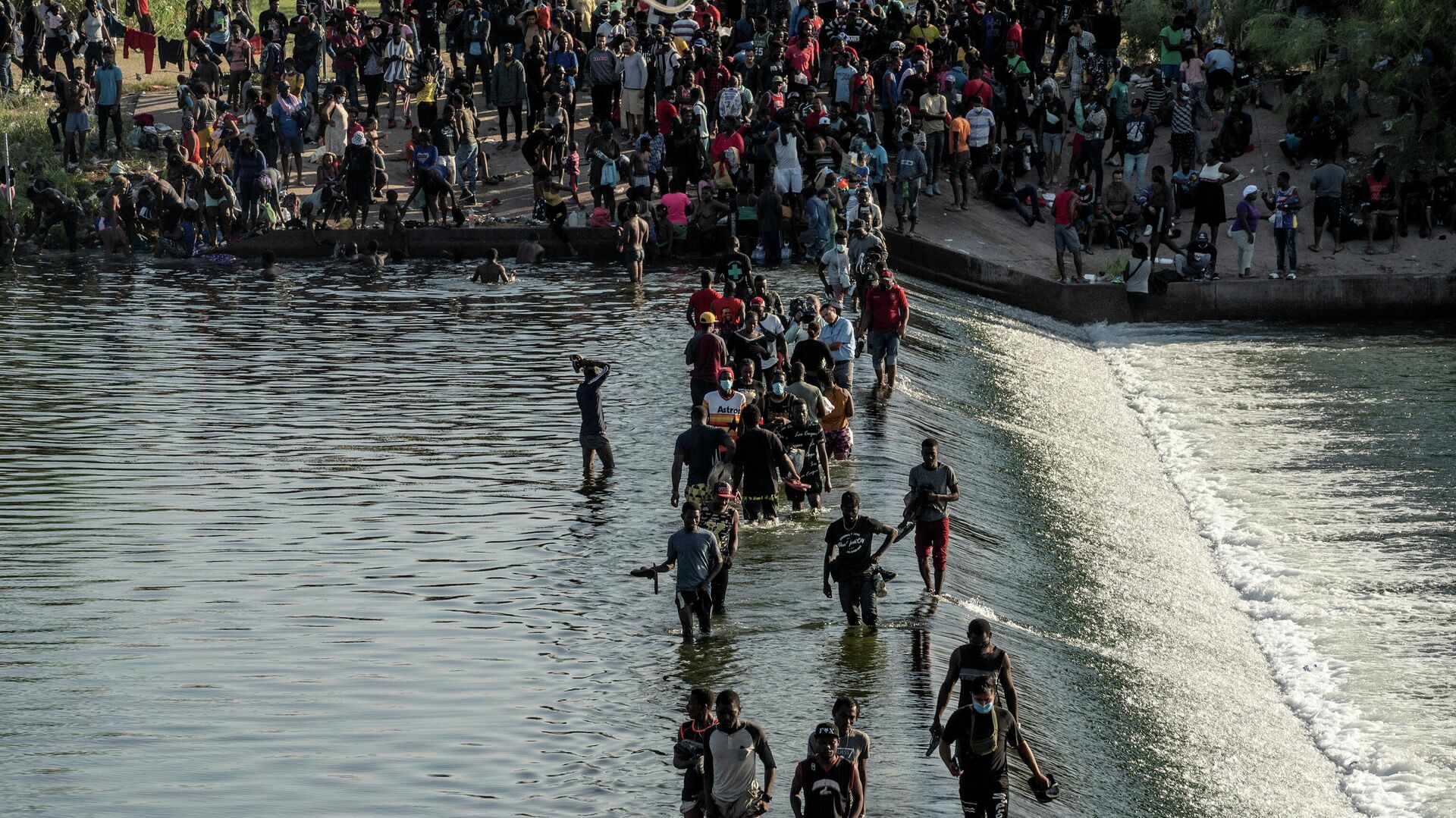 Migrants seeking asylum in the U.S. walk in the Rio Grande river near the International Bridge between Mexico and the U.S., as they wait to be processed, in Ciudad Acuna, Mexico, September 16, 2021 - Sputnik International, 1920, 17.09.2021