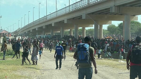 Migrants are seen by the International Bridge between Mexico and the U.S., in Del Rio, Texas, U.S., September 16, 2021, in this picture obtained from social media. Picture taken September 16, 2021 - Sputnik International
