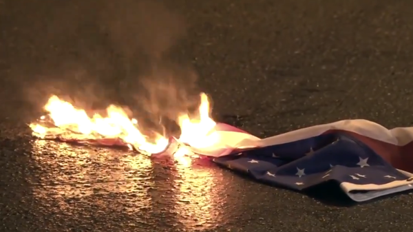 Screenshot from a video filmed during protests in Athens, Greece, against the country's NATO and EU membership, showing the US flag set on fire. - Sputnik International