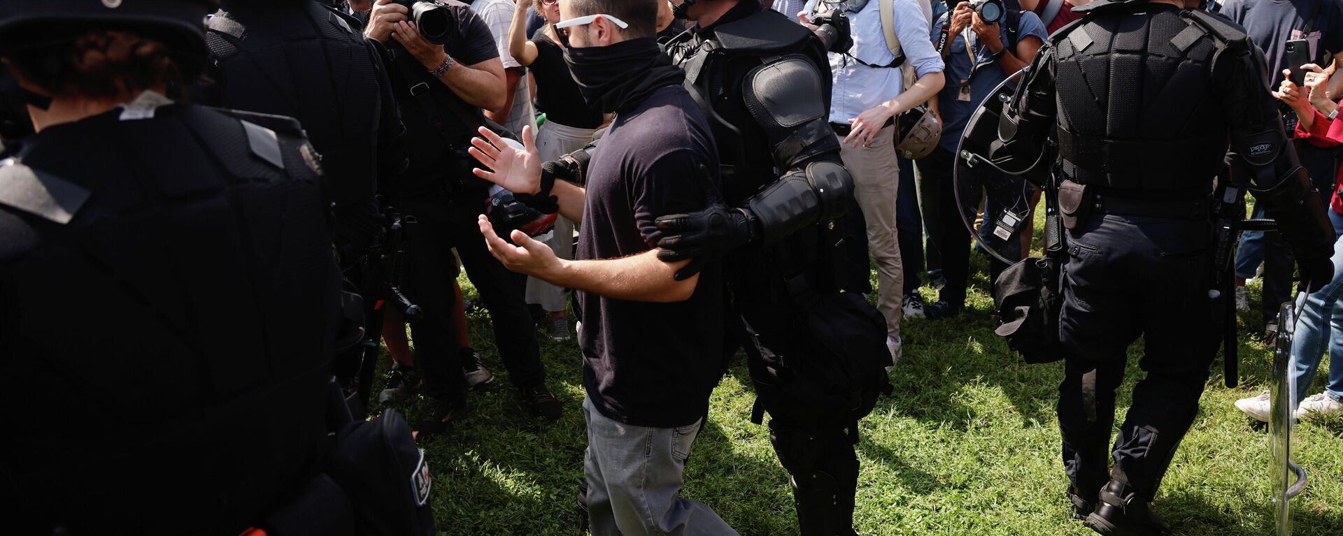 A police officer escorts a person during a rally in support of defendants being prosecuted in the January 6 attack on the U.S. Capitol, in Washington, D.C., U.S., September 18, 2021. REUTERS/Jonathan Ernst - Sputnik International, 1920, 19.09.2021