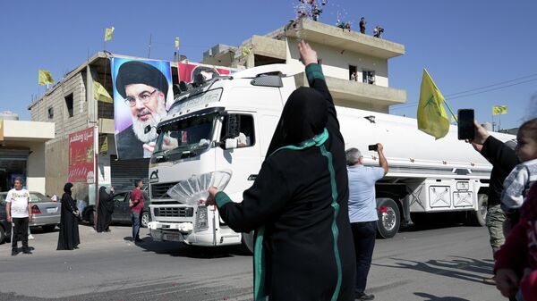 A woman throws flower petals and rice as a convoy of tanker trucks carrying Iranian fuel oil drive in al-Ain village, in northeastern Lebanon, September 16, 2021. - Sputnik International