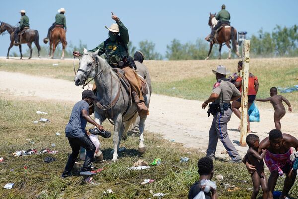 EDITORS NOTE: Graphic content / A United States Border Patrol agent on horseback tries to stop a Haitian migrant from entering an encampment on the banks of the Rio Grande near the Acuna Del Rio International Bridge in Del Rio, Texas on 19 September 2021.  - Sputnik International