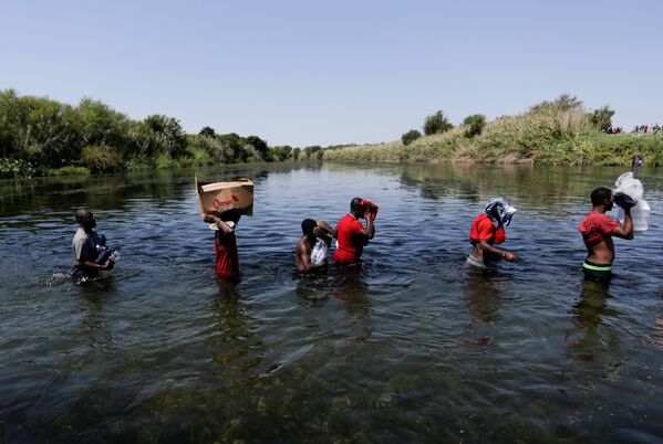 FILE PHOTO: Would-be immigrants wade through the Rio Grande river to cross the border between Ciudad Acuna, Mexico and Del Rio, Texas, US, after buying supplies on the Mexican side, in Ciudad Acuna, Mexico, 19 September  2021. - Sputnik International