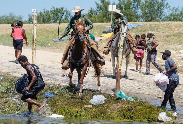 United States Border Patrol agents on horseback try to stop Haitian migrants from entering an encampment on the banks of the Rio Grande near the Acuna Del Rio International Bridge in Del Rio, Texas on 19 September 2021.  - Sputnik International