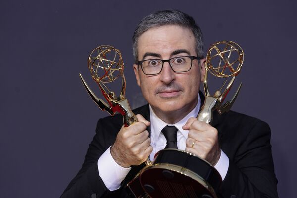 John Oliver poses for a photo with the awards for Outstanding Writing for a Variety Series and Outstanding Variety Talk Series for Last Week Tonight with John Oliver at the 73rd Primetime Emmy Awards.  - Sputnik International