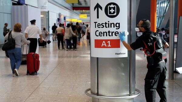 A worker sanitises a sign at the International arrivals area of Terminal 5 in London's  Heathrow Airport, Britain, August 2, 2021 - Sputnik International