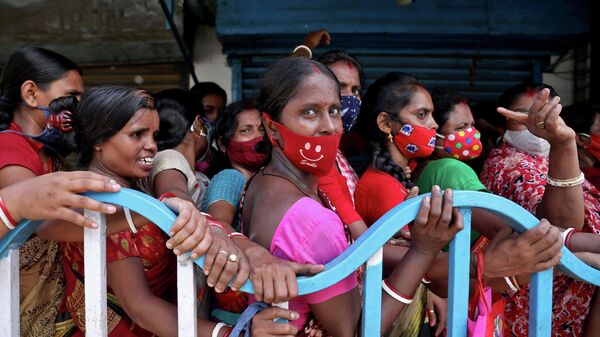 Women wait to receive a dose of COVISHIELD vaccine, a coronavirus disease (COVID-19) vaccine manufactured by Serum Institute of India, outside a vaccination centre in Kolkata, India, August 31, 2021 - Sputnik International