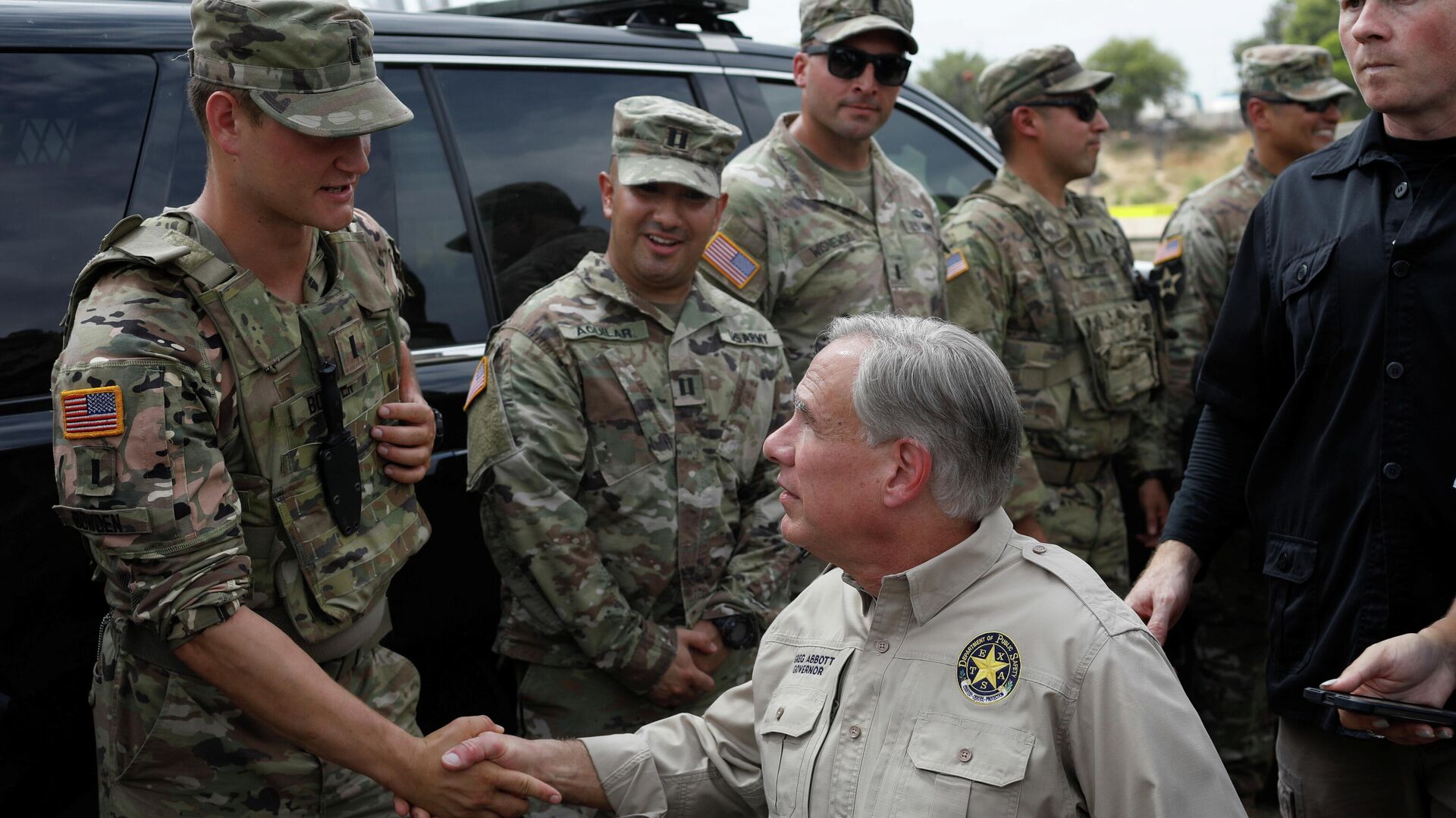 Texas Governor Gregg Abbott shakes hands with a U.S. Soldier after a news conference near the International Bridge between Mexico and the U.S., where migrants seeking asylum in the U.S. are waiting to be processed, in Del Rio, Texas, U.S., September 21, 2021 - Sputnik International, 1920, 21.09.2021