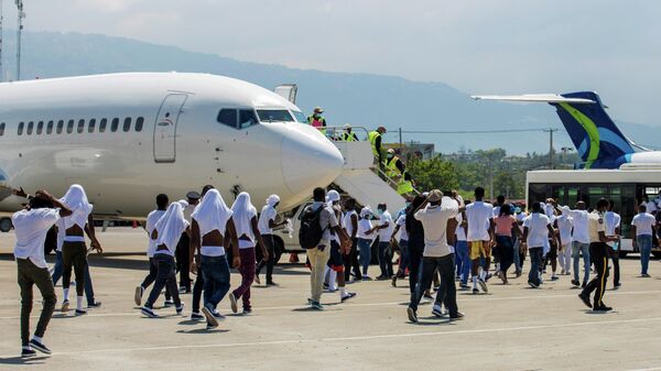 Haitian migrants board an airport bus aftter U.S. authorities flew them out of a Texas border city after crossing the Rio Grande river from Mexico, at Toussaint Louverture International Airport in Port-au-Prince, Haiti September 21, 2021 - Sputnik International
