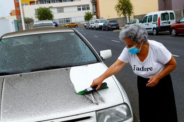 Ana Rodriguez cleans a car after the eruption of a volcano in Los Llanos de Aridane on the Island of La Palma. - Sputnik International