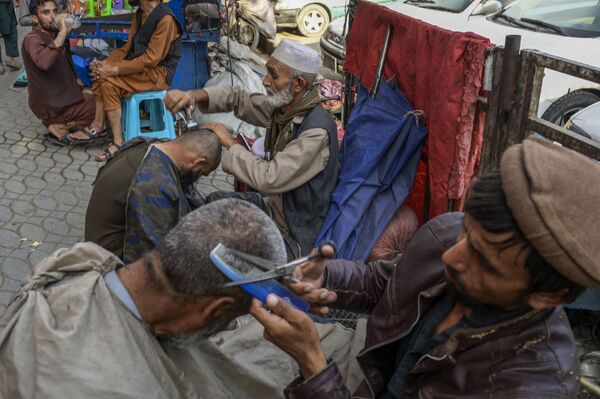 In this picture taken on 22 September 2021, street barbers attend to their customers in Kabul. - Sputnik International